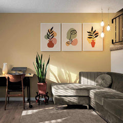 Set de cuadros decorativos con marialuisa blanca y fondo beige: maceta con rama y figuras coloridas, arte abstracto con silueta de rostro y diseño repetido floral
