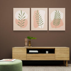 Set de cuadros decorativos minimalistas con figuras blancas y rosa sobre fondo beige, acentuados por ramitas verdes sutiles.