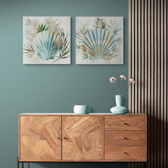 Set de cuadros decorativos con fondo beige, destacando conchas en tonos turquesa y amarillo arena, complementadas por hojas verdes sutiles.