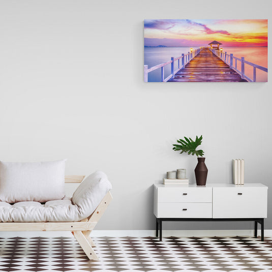 Fotografía de un muelle iluminado al atardecer con cielo colorido