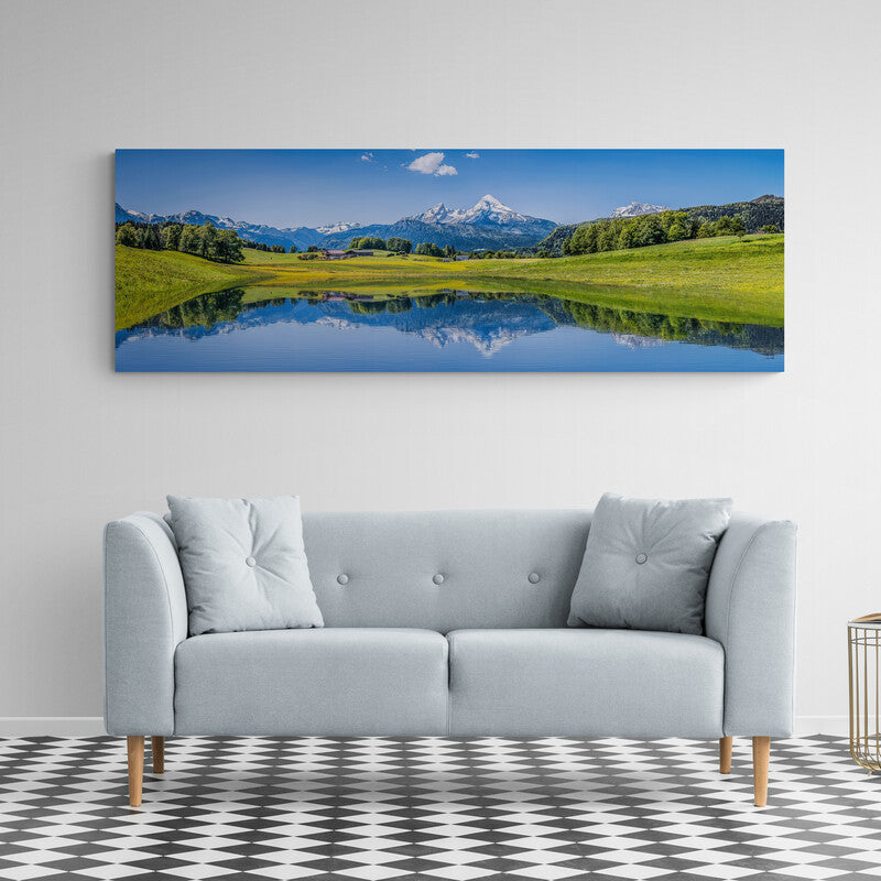 Fotografía artística de un vasto campo verde y lago bajo un cielo soleado con árboles y montañas al fondo en un paisaje pastoral luminoso