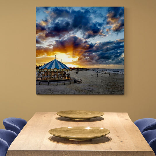 Fotografía de un carrusel en la playa al atardecer con cielo nuboso